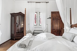 A bedroom with a large bed, a wooden wardrobe, and a window with curtains. - Boutique Villa Anna Split (Split)