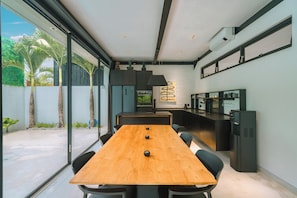 Enjoy a spacious room with a large table, comfortable seating, and a kitchen area featuring a refrigerator and microwave.