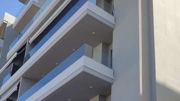 Un immeuble à plusieurs étages, doté de balcons, de grandes fenêtres et d’une façade plane.