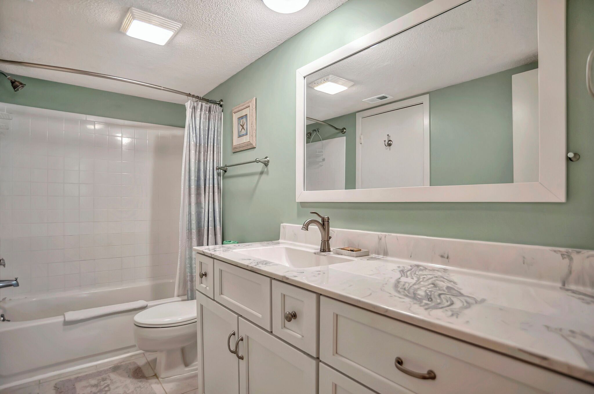 A bathroom with a bathtub, toilet, and sink.