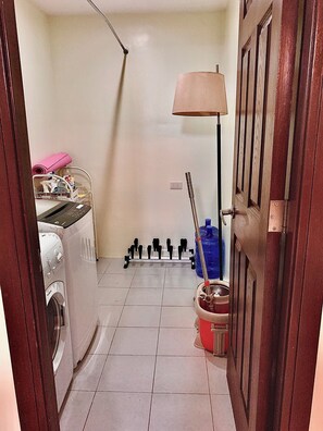 Guests can access a convenient laundry area with a washing machine and drying rack.