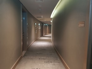 Explore the hotel's modern corridor, lined with framed pictures and a polished floor featuring historic milestones.