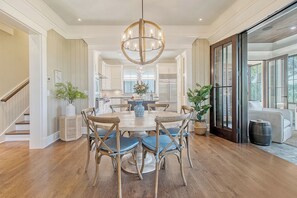 A spacious kitchen with white cabinets, a central island, and a chandelier.
