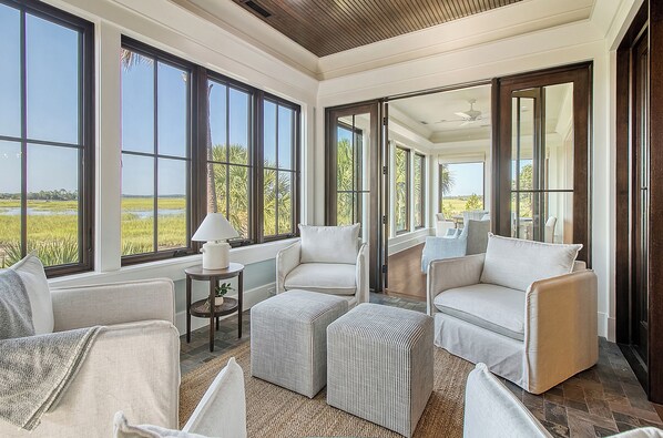 A spacious room with large windows, a ceiling fan, and a view of a field.