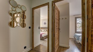 Une pièce dotée d’un plancher en bois, d’un lit avec une tête de lit blanche et d’un mur orné de plusieurs miroirs.