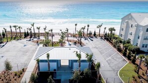 An aerial view of a parking lot with a building in the center, surrounded by palm trees and a beach in the background. - Minutes to Multiple Beach Access Points + Private Pool + Backyard Oasis (Santa Rosa Beach)