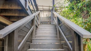 A wooden staircase with metal railings, surrounded by greenery. - Walk Everywhere From America's Most Beautiful Street by Lucky Savannah (Savannah)