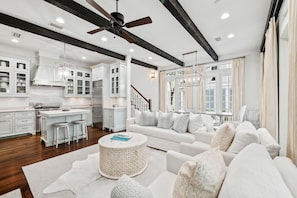 A modern kitchen with white cabinetry, a central island, and bar stools.