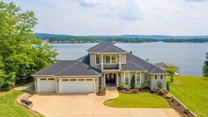 A two-story house with a garage, a driveway, and a well-maintained lawn.