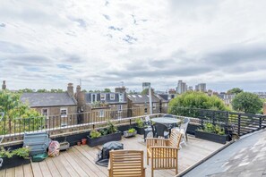 Enjoy panoramic views of the city from this rooftop terrace, surrounded by lush greenery and comfortable seating.