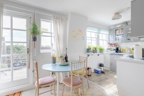 Enjoy cooking in this well-equipped kitchen with a blue table, coffee maker, and kettle.