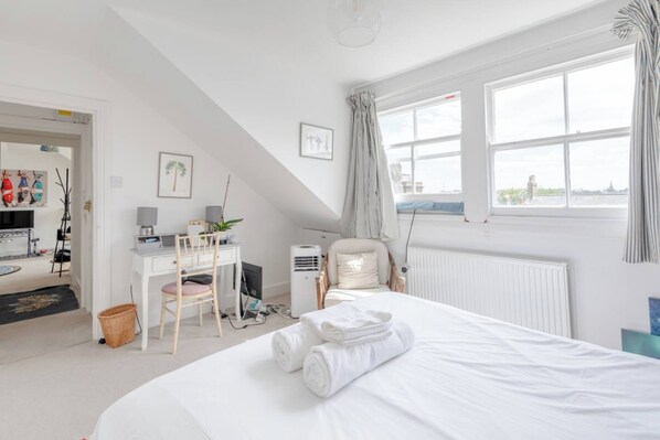 Relax in a spacious room with a large bed, desk, and city view.