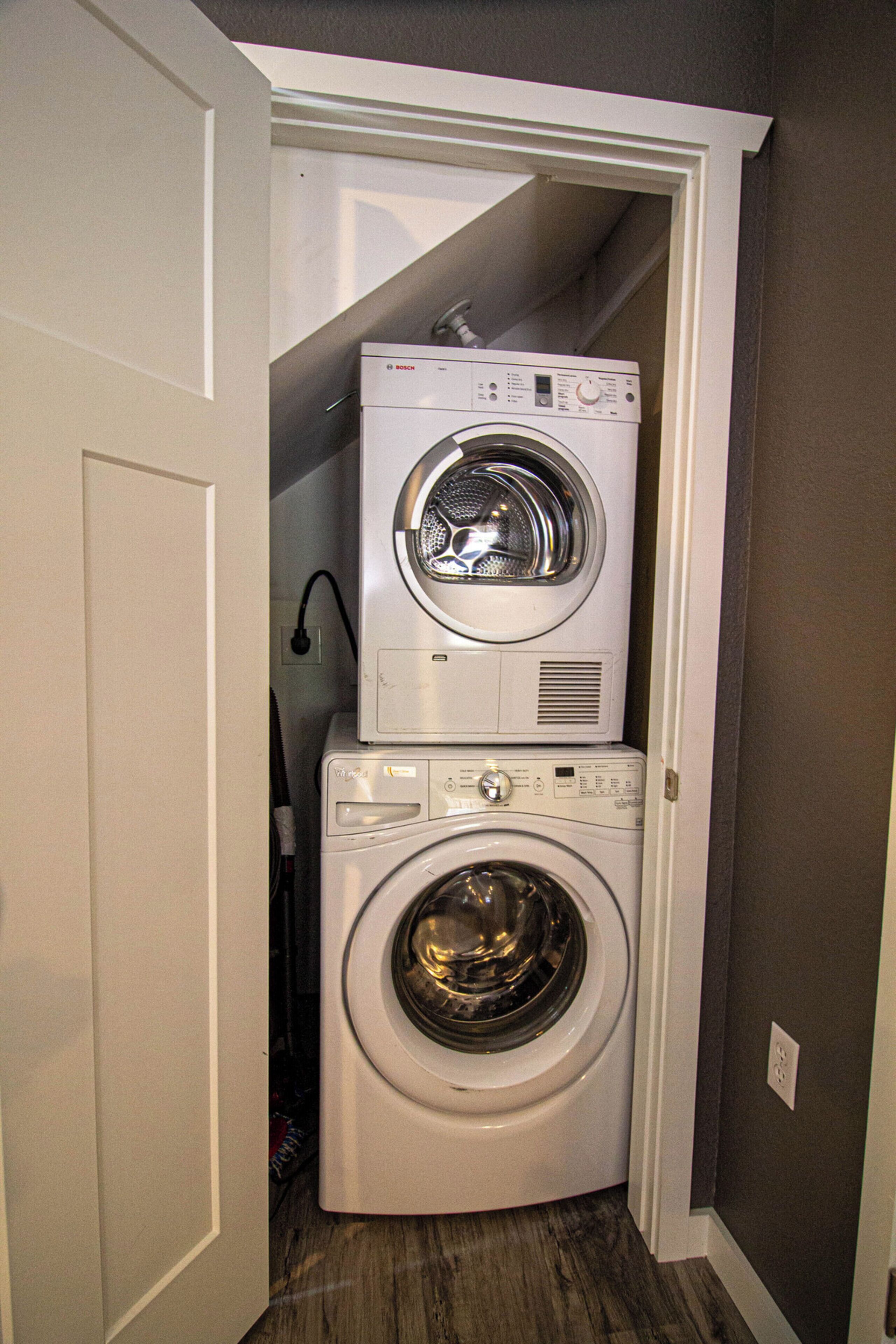 A compact laundry room with a stacked washer and dryer.
