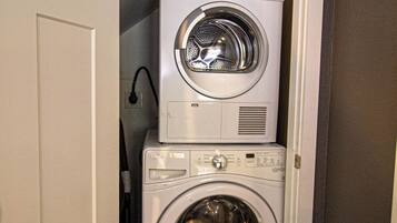 A compact laundry room with a stacked washer and dryer.