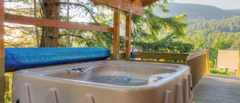 Un bain à remous installé sous une pergola en bois, avec un panneau indiquant qu’il est interdit de faire du bruit après 22 heures.