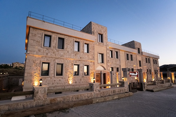 Un edificio de piedra con múltiples ventanas y un letrero que indica que es un hotel de primera categoría.