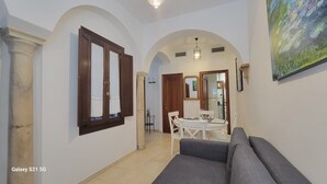 A spacious living area with a sofa, a dining table with chairs, and a kitchen in the background. - Centro Histórico de Sevilla XIX (Sevilla)