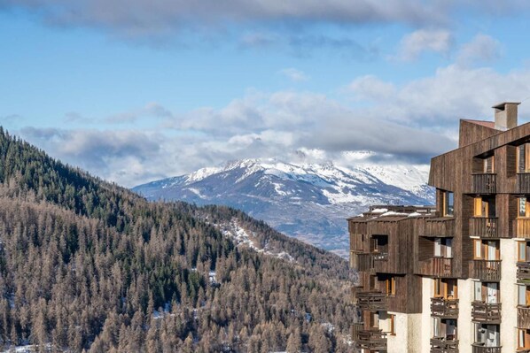 A modern building with balconies overlooking a snowy mountain range. - 100m from ski slopes, 7th floor, view open, balcony, fireplace or stove, ski locker, 32m², Les Orres (Les Orres)