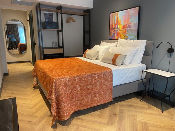 Un dormitorio moderno con una cama, una mesita de noche, un espejo y un cuadro en la pared.