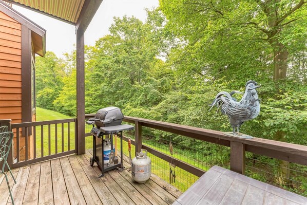 A wooden deck with a barbecue grill, a propane tank, and a rooster statue. - 7 Springs Ski & Mountain Adventure Condo 2 Bedroom Condo by RedAwning (Champion)