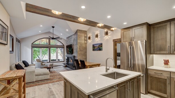 A modern kitchen with a large island, stainless steel appliances, and wooden cabinetry. - Fully Renovated 2 Bedroom in Arrowhead Village! 2 Condo by RedAwning (Edwards)