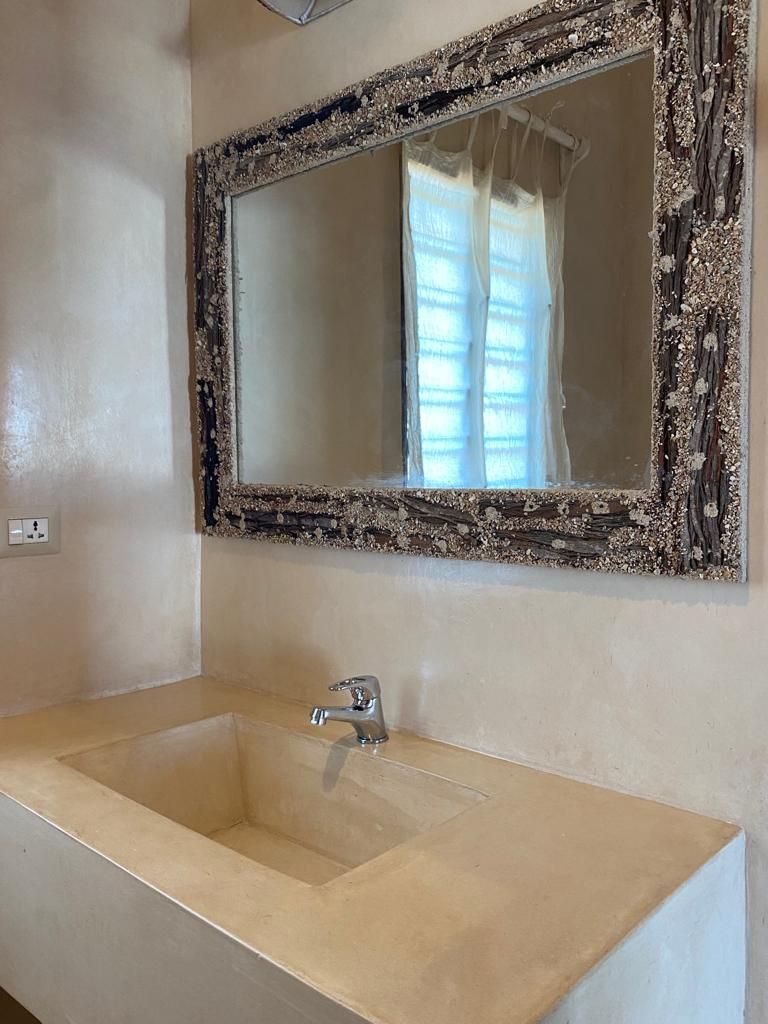 A bathroom with a large mirror, a sink, and a shower curtain.