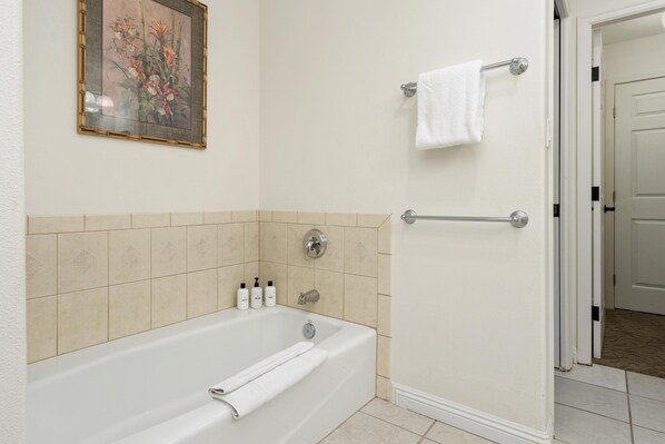 A bathroom with a bathtub, a towel rack, and a shower area. - Big Island Waikoloa Colony Villas 1206 2 Bedroom Condo (Waikoloa)