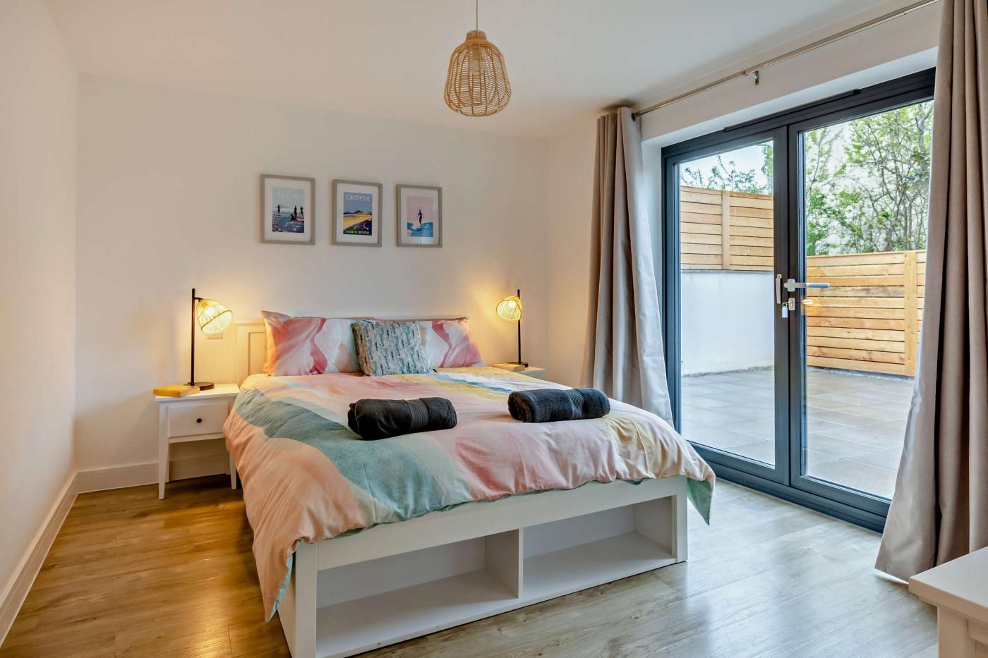 Une chambre à coucher avec un lit, des lampes de chevet, une fenêtre et une vue sur l’extérieur.