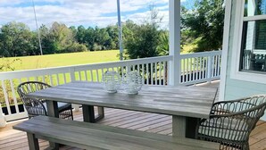 A wooden deck with a picnic table and chairs, surrounded by a white railing. - Luxury 4 Bdr Beachfront in Hilton Head- DC Breeze STR Permit # 029136 (Hilton Head Island)