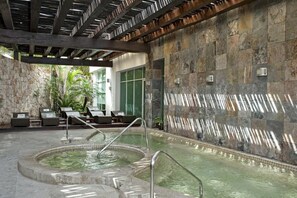 Relax by the pool surrounded by a pergola and lounge chairs.