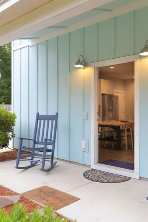 Welcome to this cozy home, where a rocking chair invites you to relax outside the entrance.