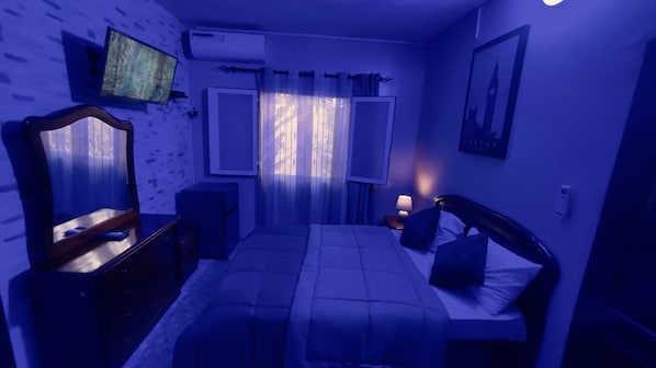 Cozy retreat with a bed, bedside table, and mirror.