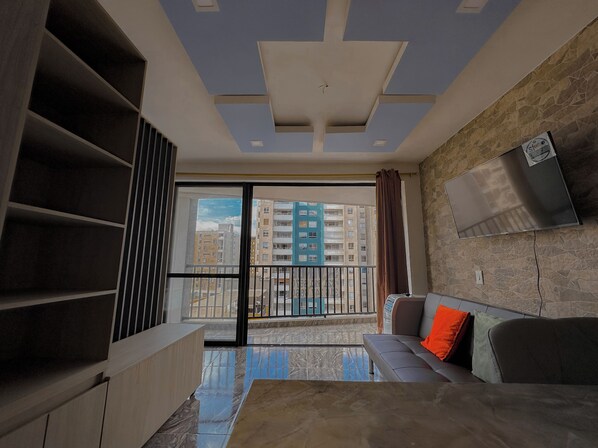 Habitación individual básica | Área de sala de estar | Televisión de pantalla plana 