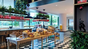 A modern cafe with a checkered floor, wooden tables, and a variety of food and drink options.