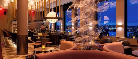 A modern interior with a bar area, seating, and a decorative glass sculpture.