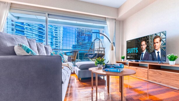 A modern living room with a sofa, a small table, and a TV displaying 'SUITS'. - Resort Experience in Puerto Madero (Buenos Aires)