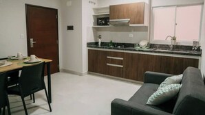 A compact kitchen with wooden cabinets, a built-in oven, and a window above the sink.