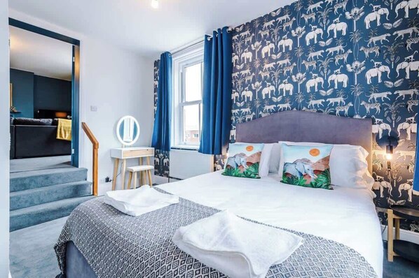 A hotel room with a large bed, a desk, and a view of the city. - ZooBlu: Chester 1-Bed (Cheshire West and Chester)