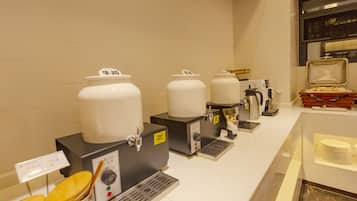 Una estación de café con varios dispensadores y una cafetera.