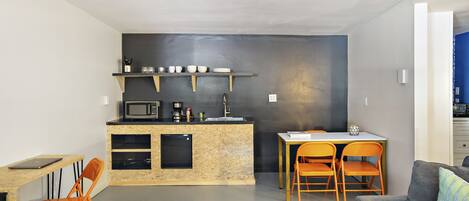 A compact living space with a kitchenette, a dining area, and a seating area.