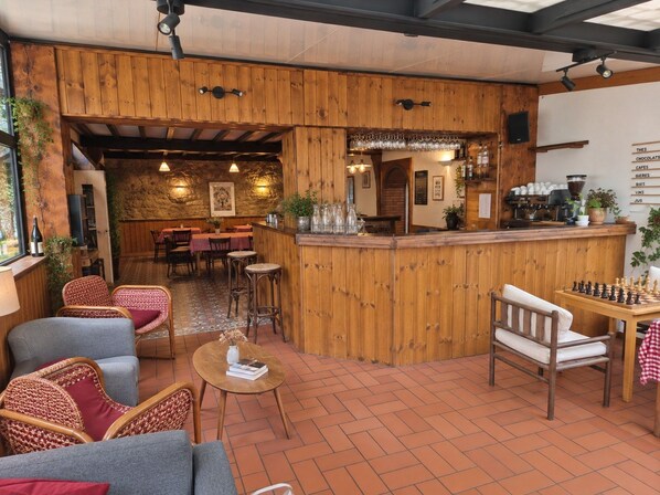 A rustic interior with wooden walls, a bar area, and seating arrangements. - Hotel Au Bon Accueil (Les Deux Alpes)