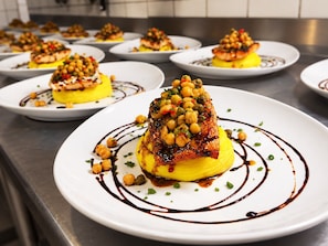 A series of plates with food, arranged on a kitchen counter. - Hotel Au Bon Accueil (Les Deux Alpes)