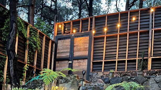 A stone staircase leading up to a wooden deck with string lights. - Mi Refugio Nordico Pequena Cabana (Donato Guerra)