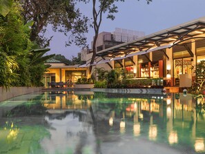 A modern hotel with a swimming pool, outdoor seating, and lush greenery. - Ibis Styles Goa Vagator (Vagator)