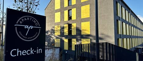 En moderne bygning med et skilt, der angiver et område for indtjekning.