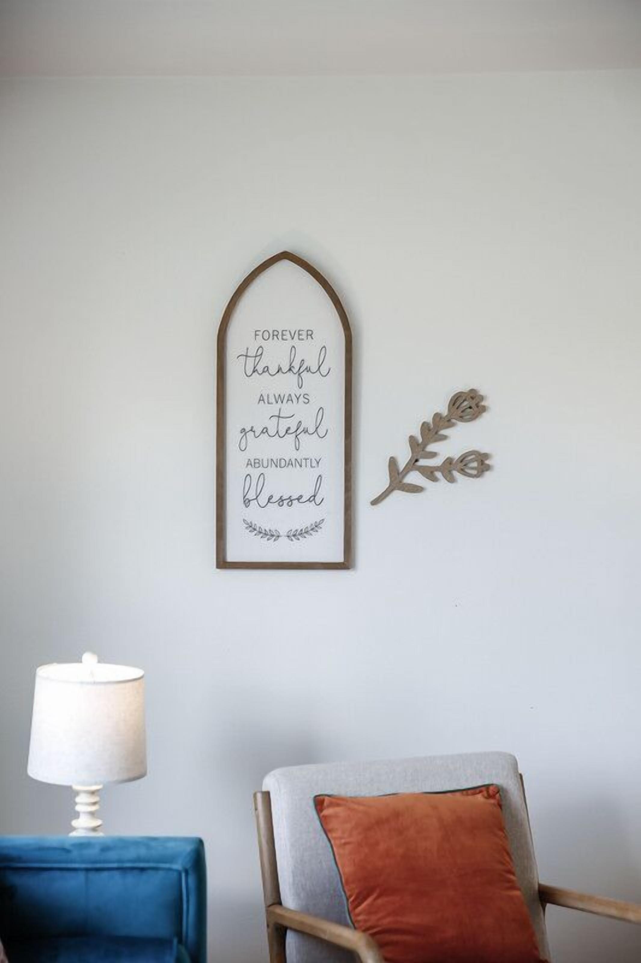 Una cita inspiradora enmarcada en una pared, una lámpara y un sillón con cojín.