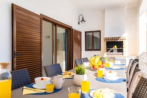 A dining area with a table set for breakfast, including plates, bowls, and glasses of orange juice.