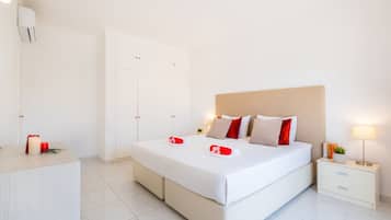 Ein Hotelzimmer mit Bett, Nachttischen, einem Kleiderschrank und einem Badezimmer.