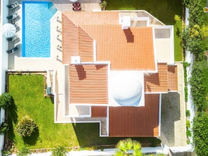A rooftop terrace with a swimming pool, a covered seating area, and a landscaped garden.