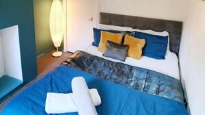 A bedroom with a bed, bedside table, lamp, and a door. - 4 Bed Town House - Reading Cent. (Reading)